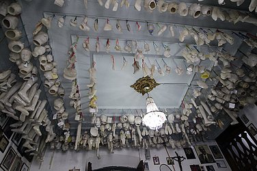 Sala de ex-votos com diversas peças de cera e madeira