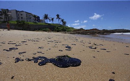 Sem proteção, voluntária passa mal após limpar praia com óleo em Salvador