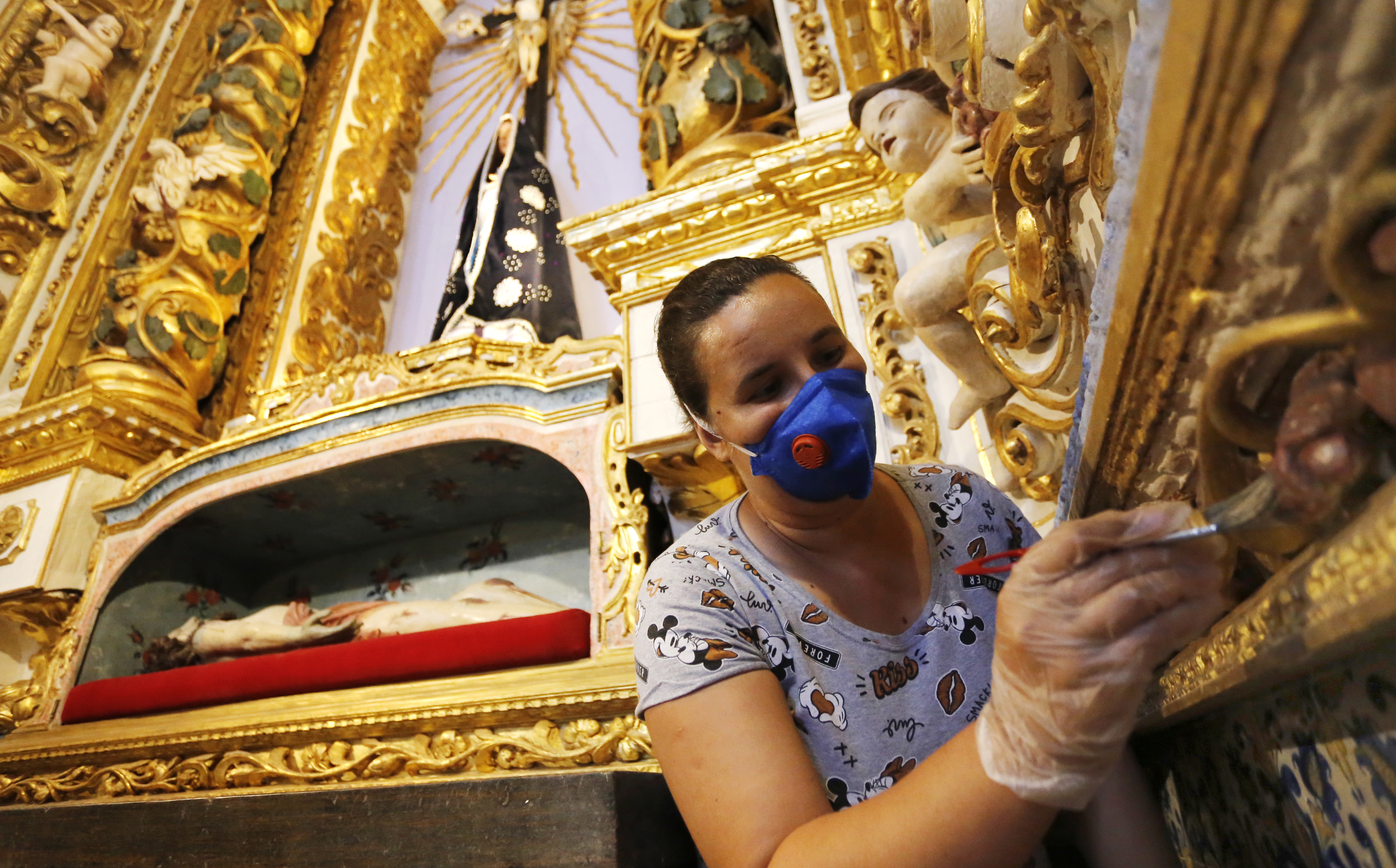 Restauradora dá os últimos retoques na capela do santíssimo.