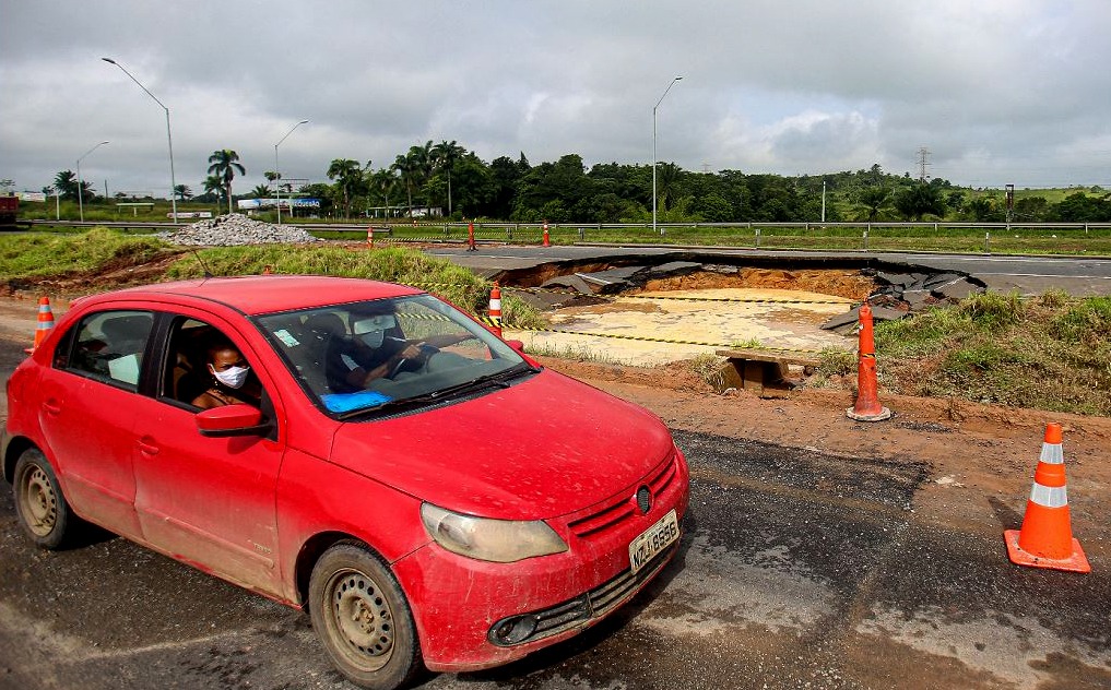 Chuva atrapalhou os trabalhos de reparo da pista da BR-324 onde surgiu uma enorme cratera. Motoristas enfrentaram engarramento.
