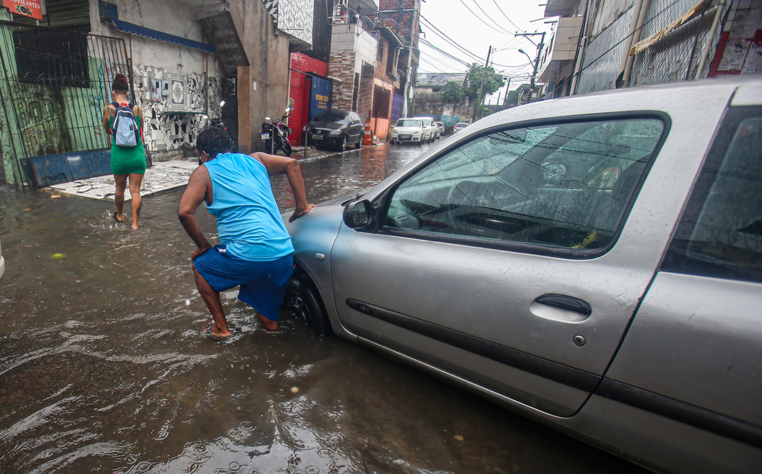 Carros ficaram presos em bueiros e buracos na pista escondidos pela água.