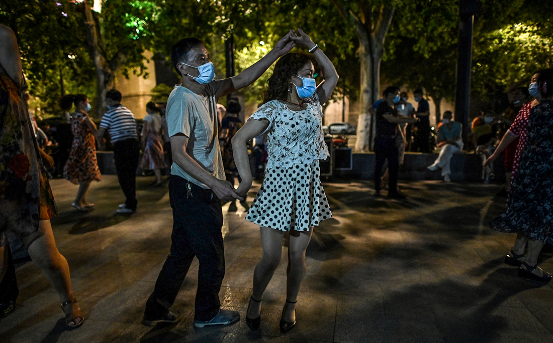 Pessoas dançam usando máscara em um parque próximo ao rio Yangtze, em Wuhan, cidade chinesa onde o coronavírus foi registrado pela primeira vez.