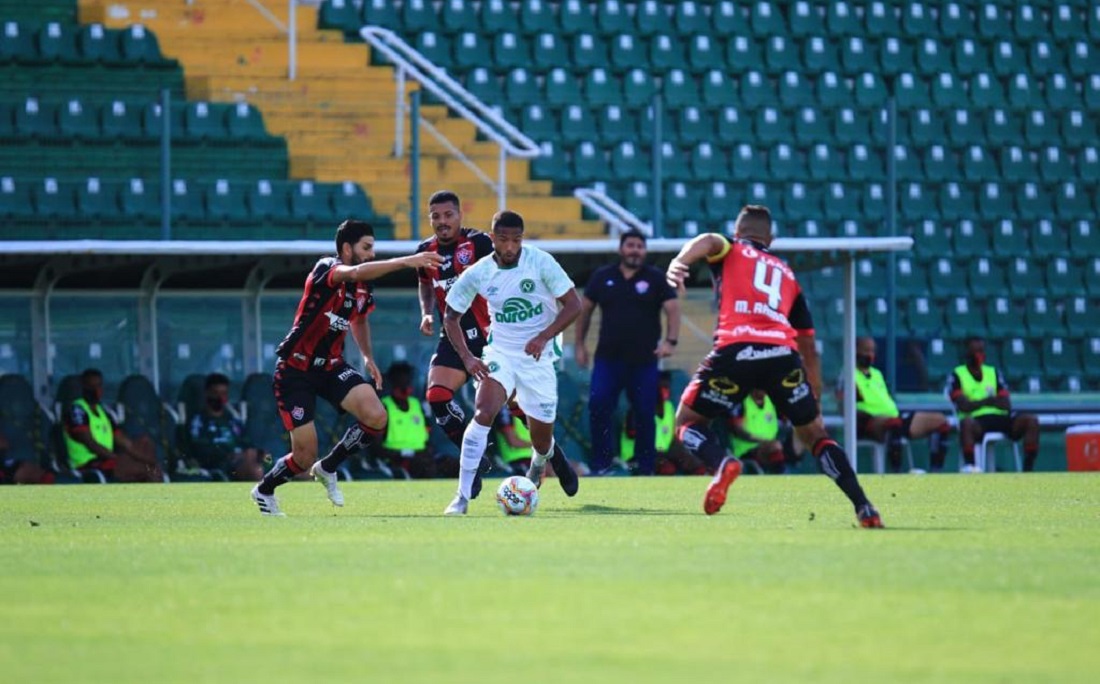 Barroca, ao fundo, observa lance do jogo entre Vitória e Chapecoense